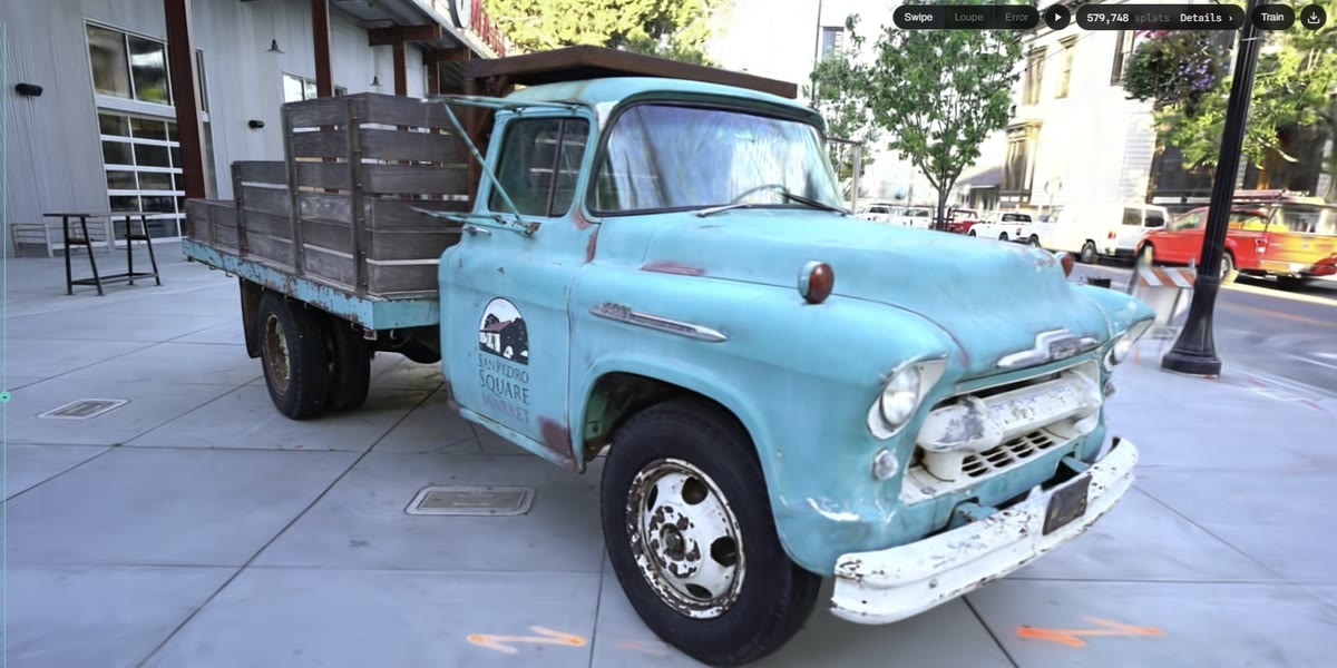 The Tanks and Temples Truck scene — a pale blue vintage flatbed pickup parked on a pavement — rendered sharply inside the Splat.js browser interface, with a readout showing 579,748 splats and a Train button in the toolbar